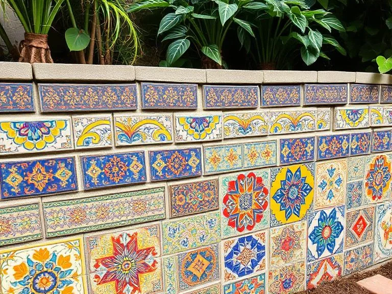 
A cinder block wall transformed into outdoor art with colorful mosaic tile patterns covering the surface, vibrant blues, yellows, and reds in Mediterranean-inspired geometric designs, decorative garden feature, detailed close-up showing intricate tilework and artistic craftsmanship